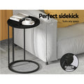 Round black side table beside sofa, text: perfect sidekick suits any space, floor protector callout, cup and book on top