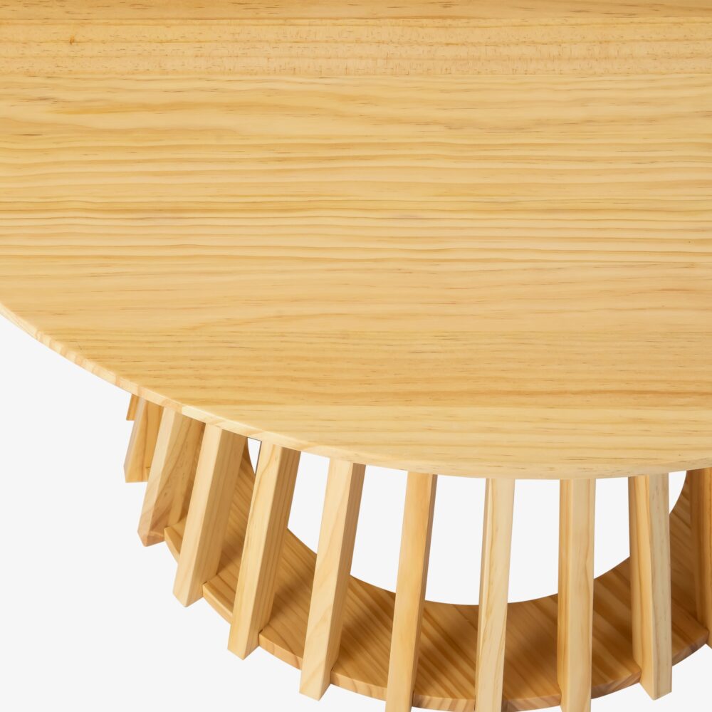 Close-up detail of round pine coffee table showing circular top surface grain and upper portion of the flared slatted