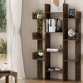 Dark brown asymmetric tree-style bookcase with staggered shelves, styled with books and plants in a bright living room