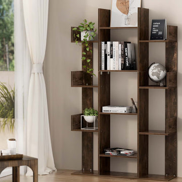 Dark brown asymmetric tree-style bookcase with staggered shelves, styled with books and plants in a bright living room