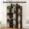 Dark brown tree bookcase with books and plants in a living room; text reads 12mm thick particle boards