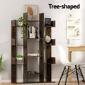Dark brown tree-shaped bookcase styled with books, plants, and globe in a home study; text reads Tree-shaped