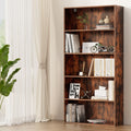 5-tier rustic walnut bookshelf styled with books and decor next to sheer curtain window and tropical plant, angle view