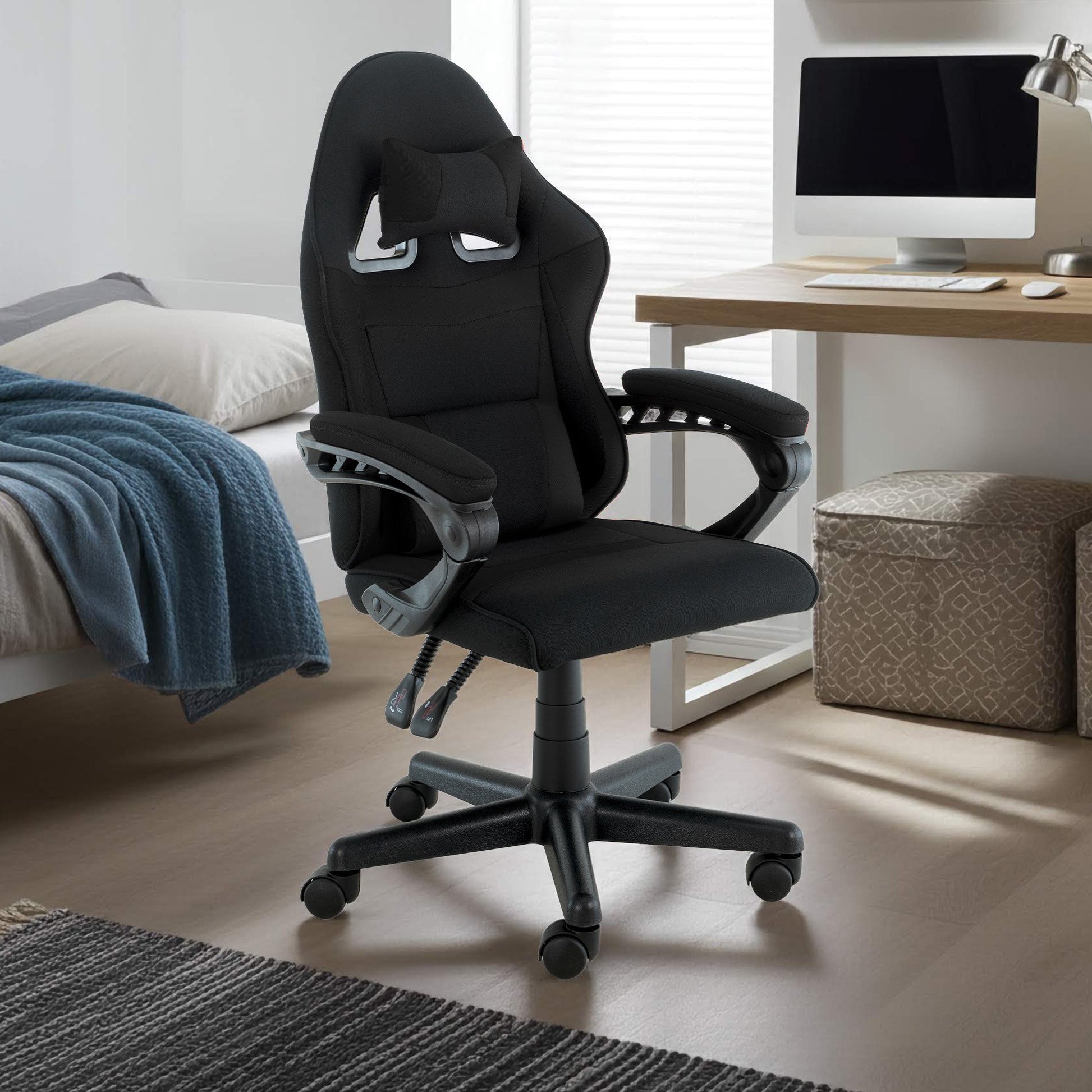 Sarantino all-black kids gaming chair in bedroom next to timber desk with computer monitor, rug and storage cube