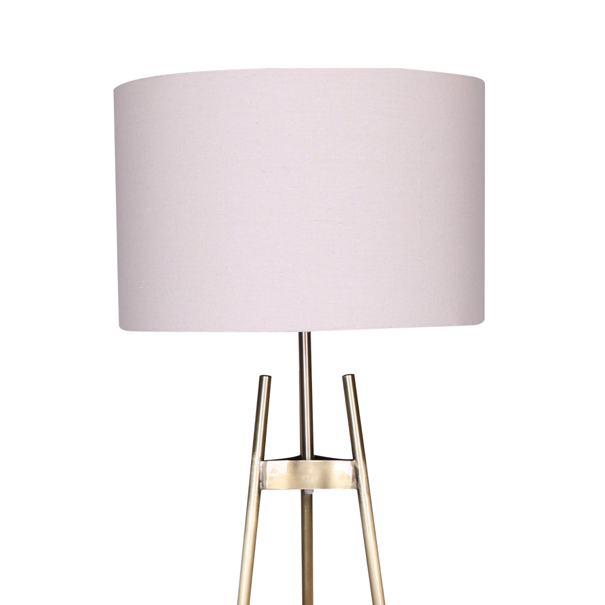 Close-up of large white cylindrical drum shade on gold brass tripod floor lamp, legs visible below