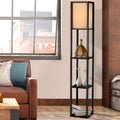 Black fabric shelf floor lamp in living room with leather sofa, three shelves holding decorative bottle and white vases