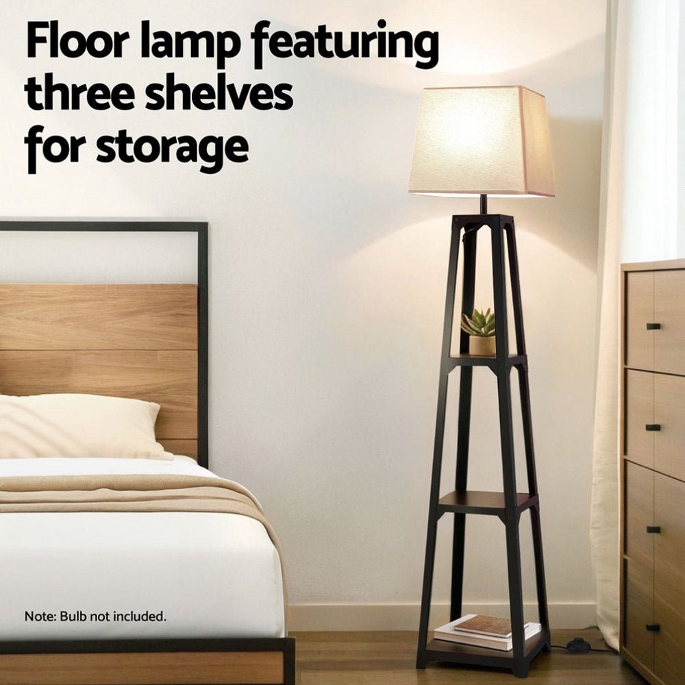 Tapered black shelf floor lamp with beige shade in bedroom scene next to bed, text overlay floor lamp featuring three shelves