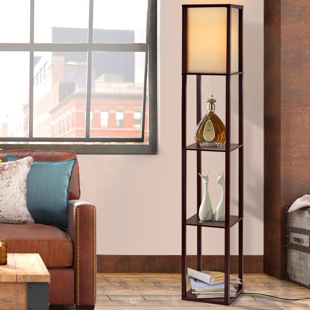 Brown shelf floor lamp with plain fabric shade in living room scene, three shelves with decorative bottle and white vases