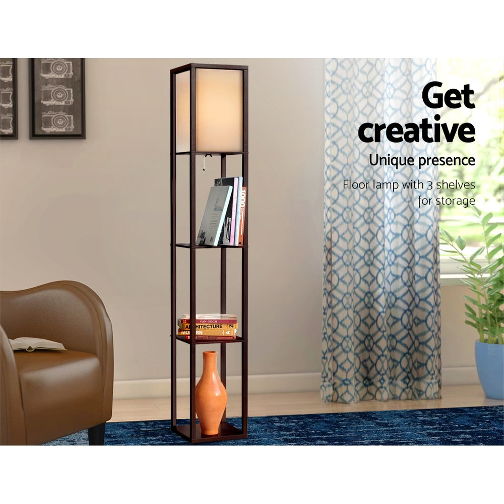 Brown fabric shelf floor lamp in living room with books and orange vase on shelves, text overlay floor lamp with 3 shelves