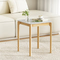 Square side table with white marble-effect top and natural wood legs beside cream sofa on patterned rug