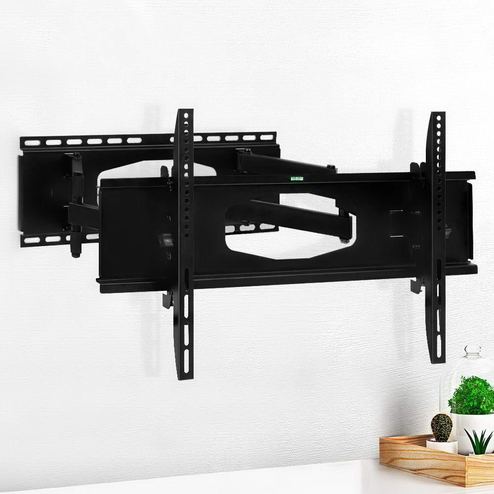 Full-motion single-arm TV wall bracket on white textured wall arms extended with green plants and cactus on wood tray