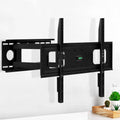 Full-motion single-arm TV wall bracket on white textured wall lifestyle with green plant and cactus on wood tray corner