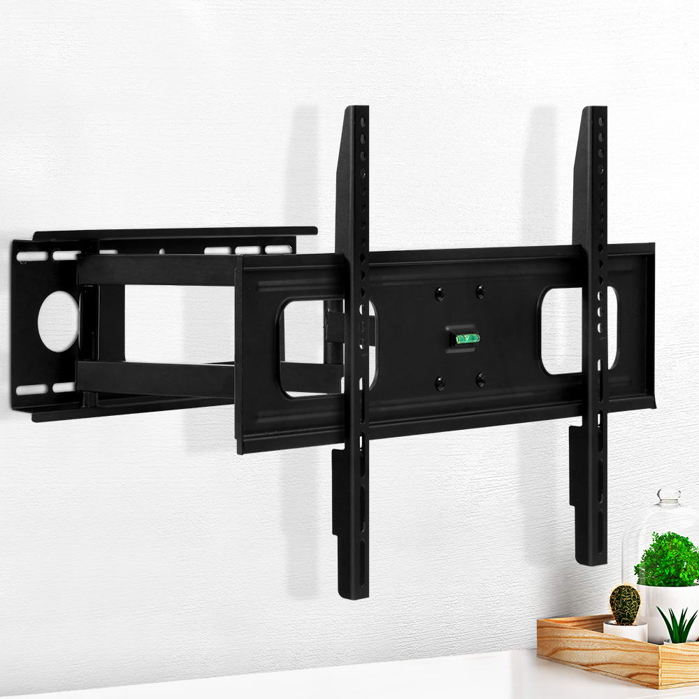 Full-motion single-arm TV wall bracket on white textured wall lifestyle with green plant and cactus on wood tray corner