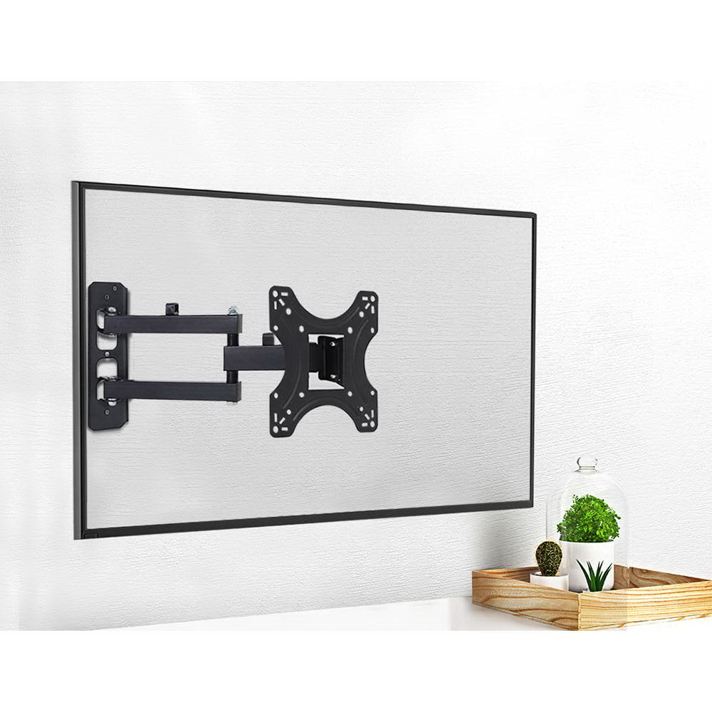 Small full-motion TV wall bracket lifestyle with TV on white wall plants in wood tray and glass dome at corner