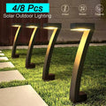 Four arch solar bollard lights glowing warm on grass beside stepping stone path, text 4/8 Pcs Solar Outdoor Lighting at top