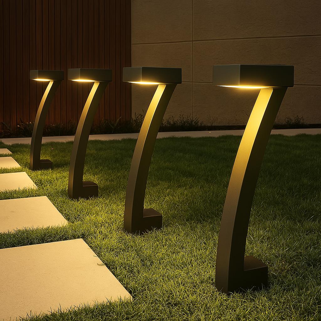 Three arch solar bollard lights glowing warm on grass beside stepping stone path at night, modern house wall in background
