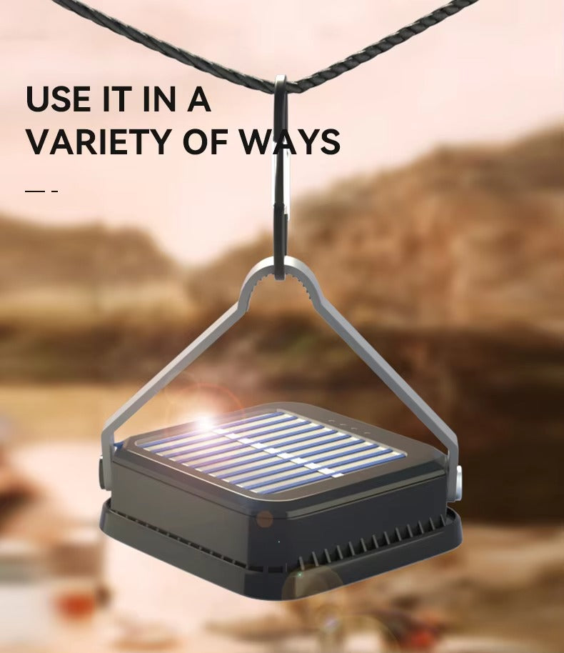 Square solar camping light hanging from rope via triangular metal hanger outdoors, text Use It In A Variety Of Ways