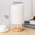 Table lamp dimensions diagram showing 14.5cm shade diameter and 20cm total height beside stacked books and cup
