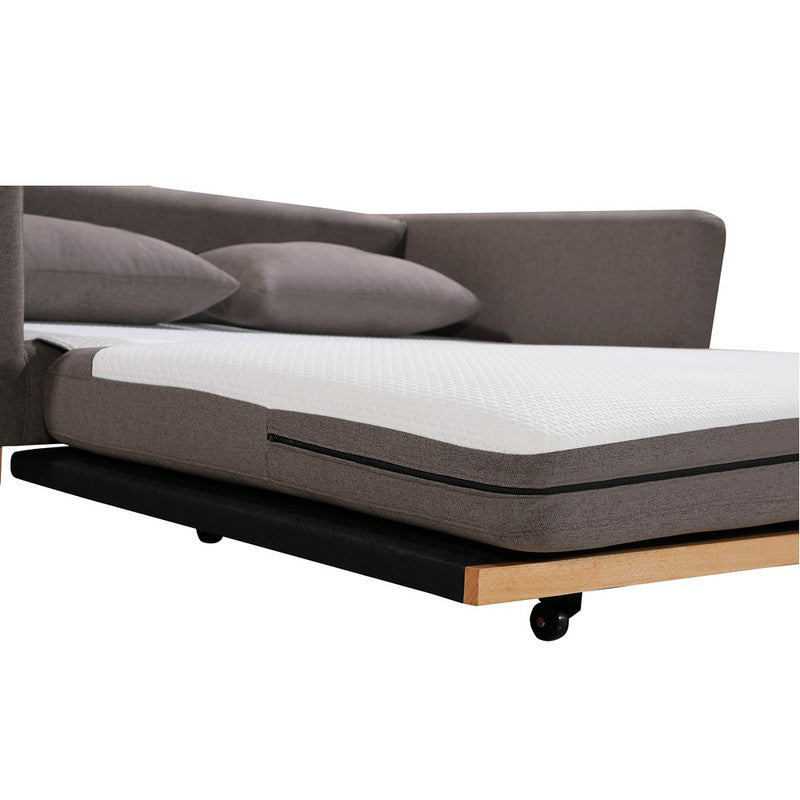 Close-up of taupe fabric sofa bed partially extended showing white mattress foot and casters on wood base
