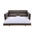 Taupe fabric sofa bed fully extended showing white mattress, two scatter pillows and wood frame with casters