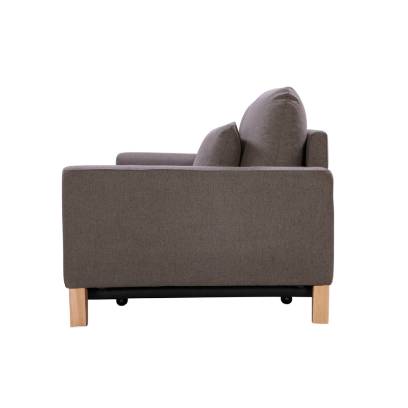 Side view of taupe fabric sofa bed with scatter pillow and wood legs on white background
