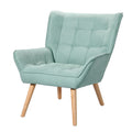 Teal green fabric armchair with grid-tufted back and seat, winged backrest, and natural wood tapered legs, angle view