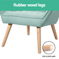 Close-up of teal tufted armchair rubberwood legs with 