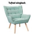 Teal green grid-tufted wingback armchair with natural wood legs, angle view, 