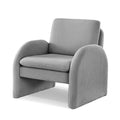 Grey boucle armchair with arched solid panel sides and cushioned seat, three-quarter angle on white background