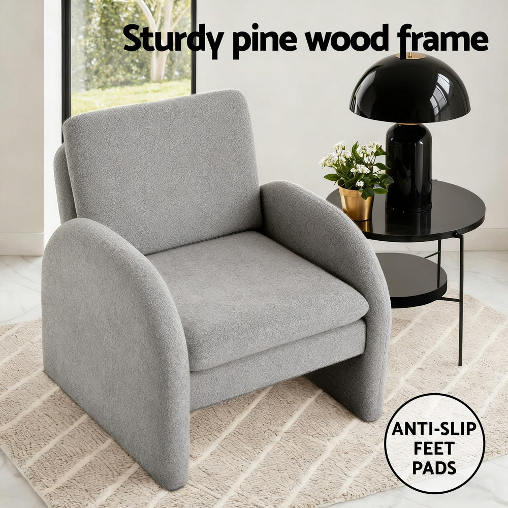 Grey boucle arch-panel armchair in room with callouts: "Sturdy pine wood frame" and "Anti-slip feet pads" badge