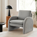 Grey boucle armchair with arched solid panel sides in modern room with black dome lamp and wooden side table