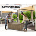 Man and woman carrying brown timber storage bench outdoors under marquee canopy; text: convenient carry
