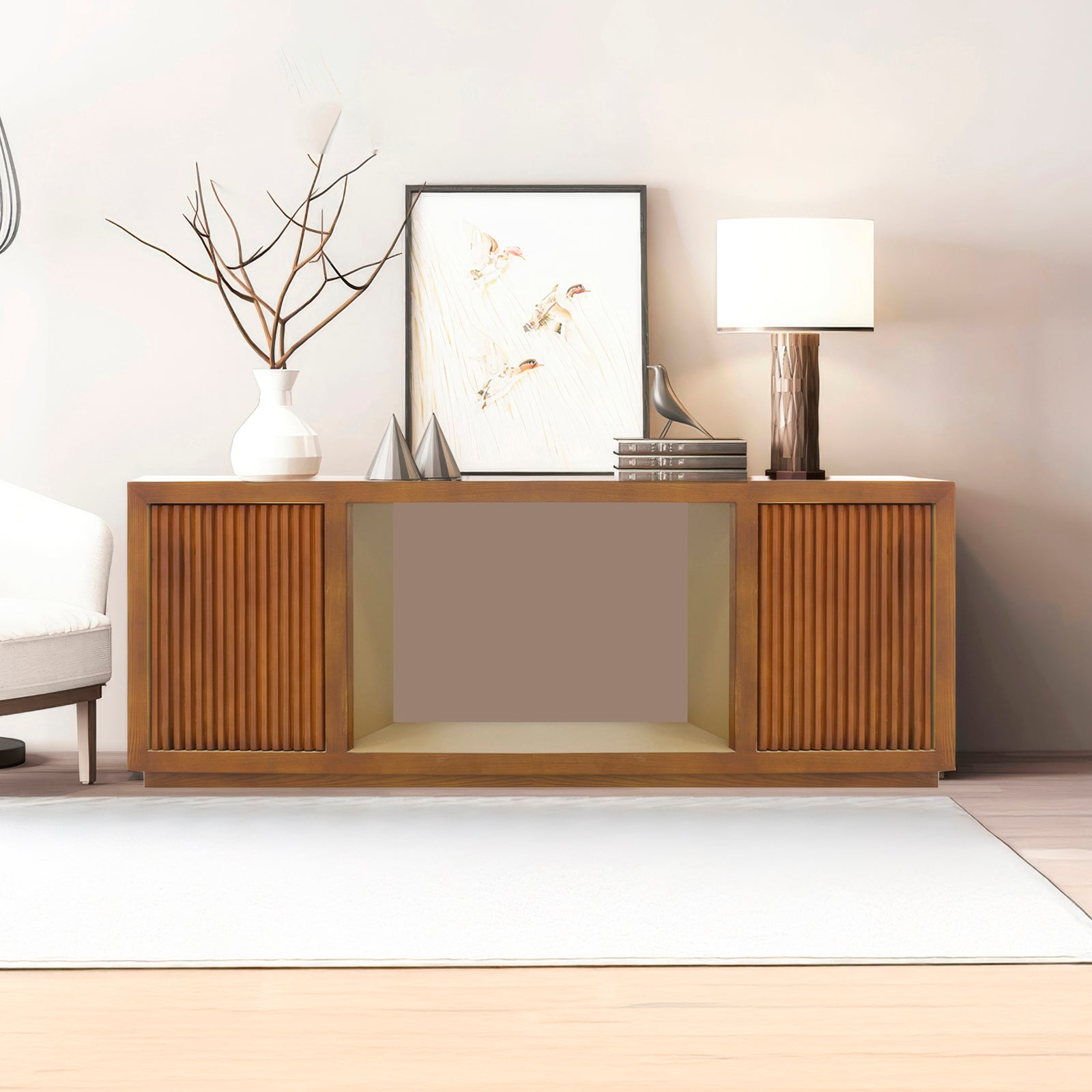 Walnut TV console with two reeded doors flanking open central bay in living room, vase, art and lamp on top, sofa beside