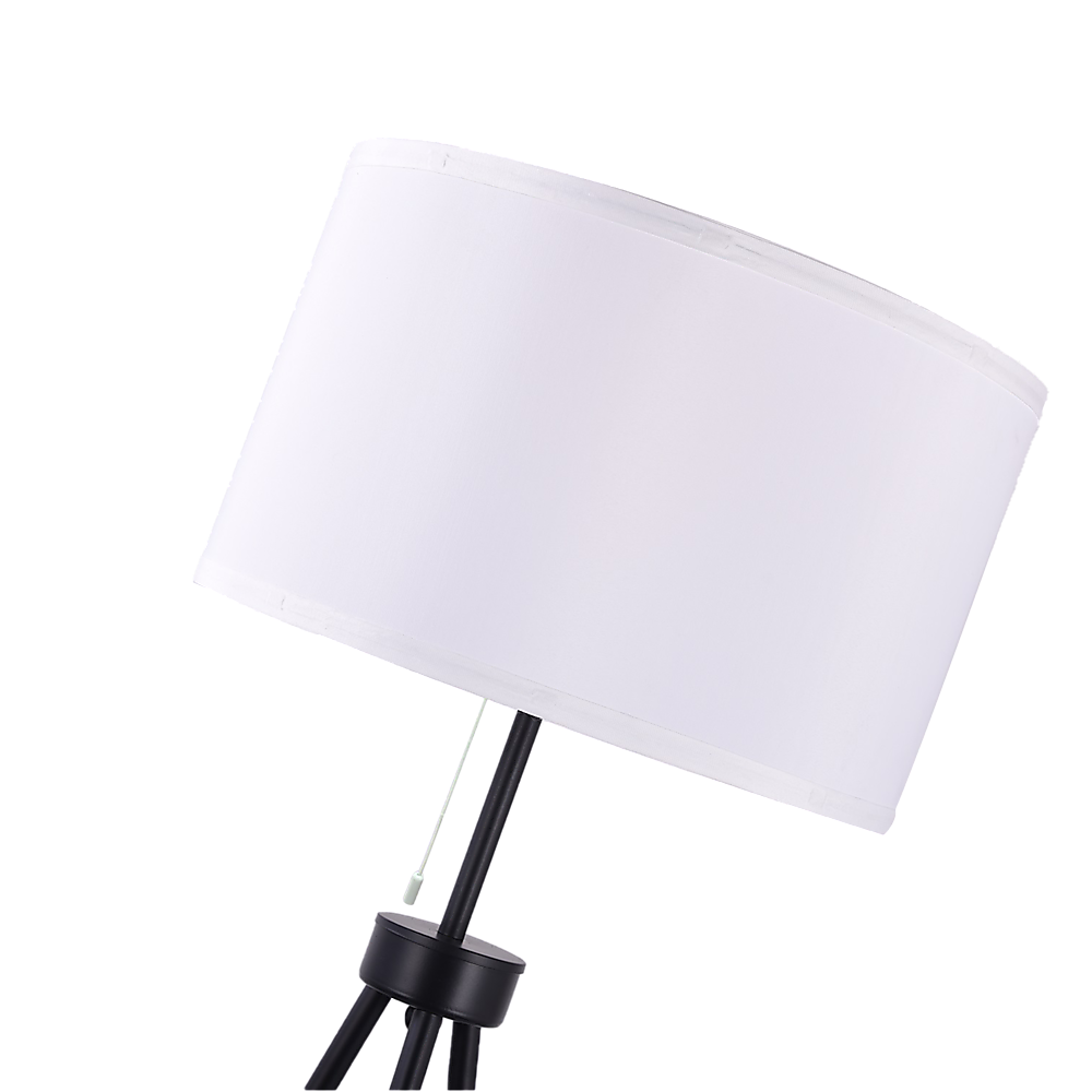 Angled close-up of white fabric drum shade and pull-chain on tripod floor lamp, tripod legs visible below