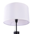 Close-up of white fabric drum shade on tripod floor lamp showing pull-chain switch and black mounting hardware