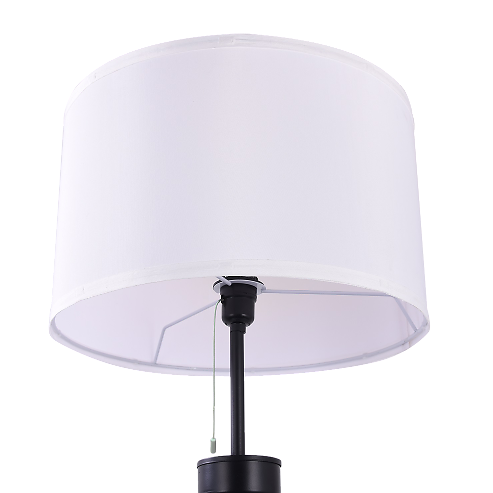 Close-up of white fabric drum shade on tripod floor lamp showing pull-chain switch and black mounting hardware