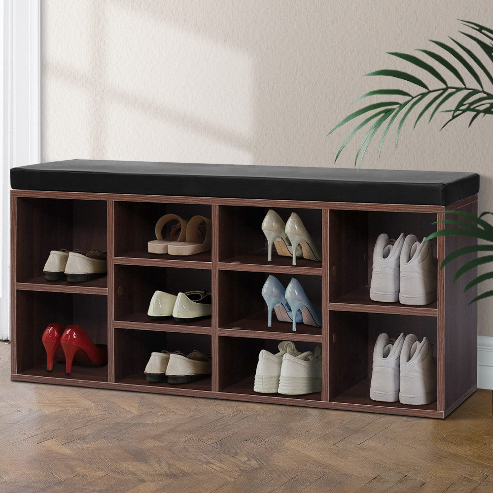 Walnut 10-cube shoe bench black cushion top all cubbies loaded with heels pumps sneakers on herringbone floor