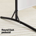White 3-panel fabric room divider round foot pedestal close-up on cream rug with black T-bar base and triangular brace