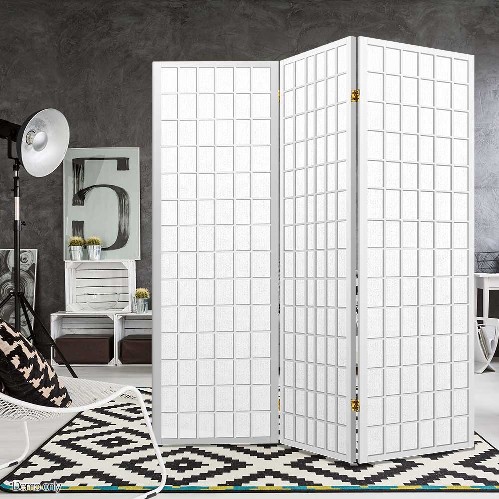 White 3-panel fabric grid shoji room divider in grey concrete lifestyle studio with tripod floor lamp and geometric rug