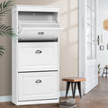 White three-tier flip-out shoe cabinet top compartment open two lower doors closed in hallway with wooden stool and shoe