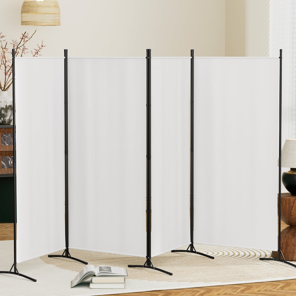 White 4-panel fabric room divider in living room lifestyle with blossoming branch lamp and open books on floor