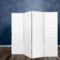 White 4-panel fabric grid shoji room divider angled view in lifestyle with blue textured concrete wall and dark wood floor