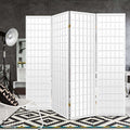 White 4-panel fabric grid shoji room divider in grey concrete lifestyle studio with tripod floor lamp and geometric rug