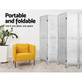 White 4-panel louvered wood room divider in living room lifestyle with yellow armchair and ZZ plant against white wall