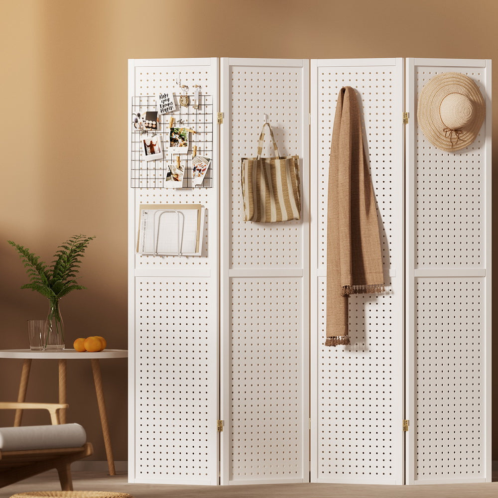 White 4-panel pegboard room divider in lifestyle room with photos on wire grid tote bag scarf and hat on hooks