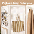 White 4-panel pegboard room divider hanging design close-up with hooks holding tote bag and scarf and wire grid panel