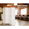 White 4-panel woven paper rope room divider in industrial office with exposed ceiling beams computer desks and brick wall