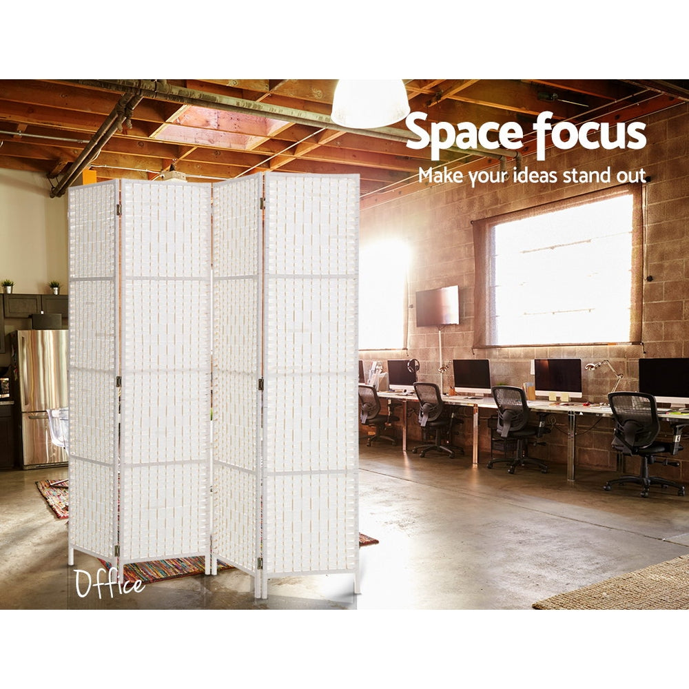 White 4-panel woven paper rope room divider in industrial office with exposed ceiling beams computer desks and brick wall