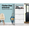 White four-tier shoe cabinet top flip-out open with black and brown shoes stored clutter-free entrance text in lifestyle