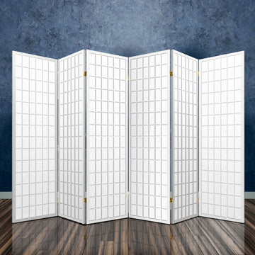 White 6-panel grid shoji room divider in room with dark stone textured wall reflective floor and brass hinges